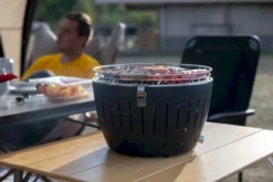 LotusGrill Classic Houtskoolbarbecue - Zwart -Oase Velda Winkel lotusgrill in gebruik met toppy shirtje 2