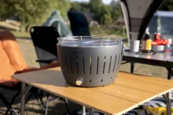 LotusGrill XL Hybrid Houtskoolbarbecue - Rood -Oase Velda Winkel lotusgrill in zon op tafel 3